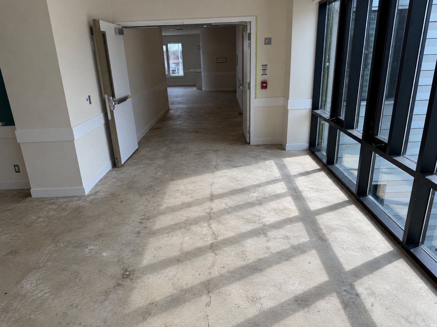 Corridor with cracked concrete subfloor before flooring installation